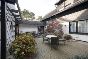 eine Terrasse mit Stühlen und einem Tisch auf einem Gebäude in der Unterkunft Landhaus Dürkop in Wolfenbüttel