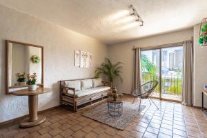 - un salon avec un canapé, une table et une fenêtre dans l'établissement Soy Local Puerto Vallarta, à Puerto Vallarta