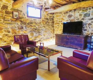 - un salon avec deux canapés et une télévision dans l'établissement Casa de Ribeira Sacra con calefacción, à Pantón