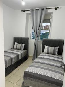 a bedroom with two beds and a window at Appartement Cosy, Calme M'diq in M'diq