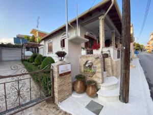 a house with a gate and some plants on the sidewalk at Barbara's House,New Luxury central apartment in Nea Kallikrateia