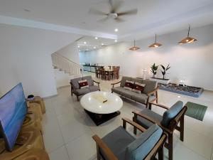 a living room with a couch and chairs and a tv at Malacca City Center Town House by 360HOME in Melaka