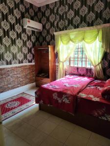 1 dormitorio con cama roja y dosel en Homestay Hassani en Kepala Batas