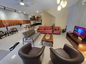 a living room with couches and a flat screen tv at Malacca City Center Town House by 360HOME in Melaka