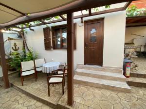a patio with a wooden door and a table and chairs at Barbara’s House,New Superior Central Studio in Nea Kallikrateia