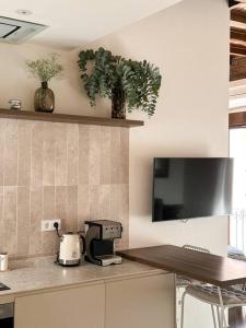 a kitchen with a counter and a tv on the wall at CETTI - Centro in Granada