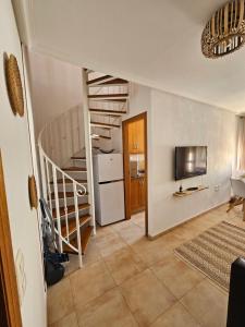 a living room with a spiral staircase and a kitchen at Ático Pola in Santa Pola