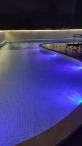 a large swimming pool with blue lights in it at Luxury Paiva Flat in Recife