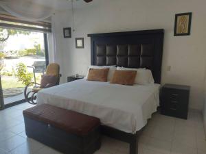 sypialnia z dużym łóżkiem i krzesłem w obiekcie Casa en Club de Golf Santa Fe w mieście Temixco