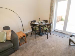 a living room with a table and chairs and a couch at 66 Dale Grove in Leyburn