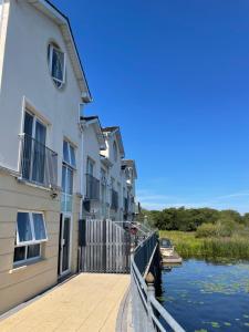 a row of buildings next to a river with a boat at Five bedroom waterfront house in Carrick on Shannon