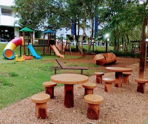 ein Park mit Tischen und Bänken und einem Spielplatz in der Unterkunft Águas da Serra Rio Quente Flats 205B in Rio Quente