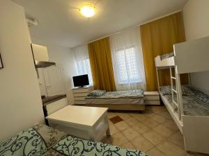 a small room with two beds and a tv at Domki i POKOJE PLAŻOWE in Darlowko