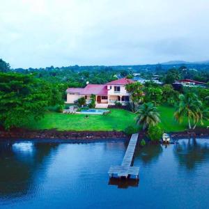 a house with a dock in the middle of a river at Te Mana Lodge in Taravao