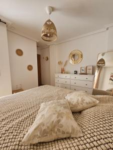 a bedroom with a bed with two pillows and a dresser at Ático Pola in Santa Pola