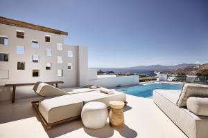 a living room with a couch and a swimming pool at Sharm Hotel Mykonos in Mikonos