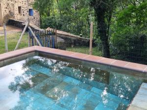 a swimming pool with blue water in a yard at Mas Violella allotjament rural in Sant Joan les Fonts