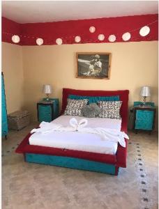 a bedroom with a large bed with a red headboard at Casa Montegri in Hal Ghaxiak
