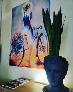 uma pintura de uma mulher em um vestido azul e uma bicicleta em Hotel Ambasador em Lezhë