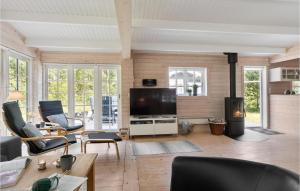 - un salon avec une télévision, un canapé et des chaises dans l'établissement Amazing Home In Hadsund With Kitchen, à Hadsund
