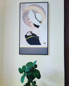 une photo accrochée sur un mur à côté d'une plante dans l'établissement Hotel Ambasador, à Lezhë