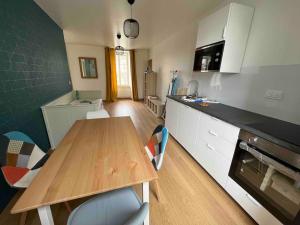 cocina con mesa de madera y encimera en La Maison des Amis en Normandie en Pontfarcy