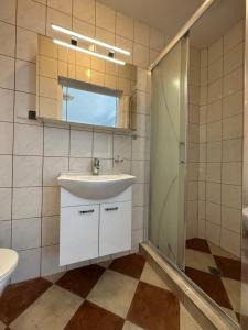 a bathroom with a sink and a shower at Domki i POKOJE PLAŻOWE in Darlowko