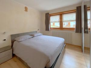 1 dormitorio con cama blanca y ventana en Skyrim Apartment - City Centre en Livigno