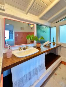 a bathroom with a sink and a large mirror at Casas D'Água Doce - Casa Bambu in Ilhabela