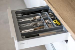 a drawer filled with utensils in a cabinet at Apartamenty Zielona Lipka in Pisz