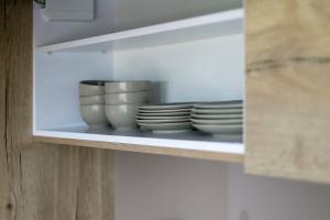 a shelf with plates and bowls on it at Apartamenty Zielona Lipka in Pisz