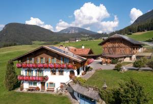 a house in the mountains with flowers on it at Binterhof in Castelrotto