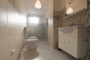 a bathroom with a toilet and a sink and a shower at [Attico Dogliani] vista Langhe in Dogliani