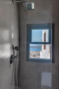a bathroom with a shower and a window with a view at ArtdecoSyros Superior in Ano Syros