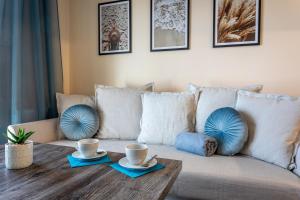 a living room with a couch with two cups on a table at Ambria Rose in Świnoujście