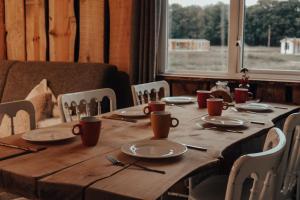 - une table en bois avec des assiettes et des ustensiles dans l'établissement Hoeve Twente - Bosuil, à Heythuysen