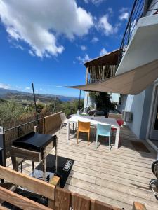 una terraza con mesa y sillas en una casa en Casa Costa, en Barbaggio