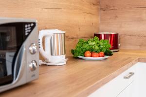 a plate of lettuce and tomatoes on a counter next to a microwave at Alphirt Ferienwohnungen in Fischen