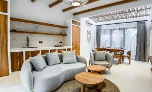 uma sala de estar com um sofá e uma mesa em Hutan Villa by EVDEkimi Ubud em Ubud