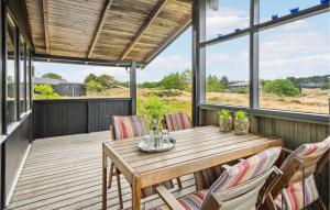 een houten tafel en stoelen op een terras bij Gorgeous Home In Fan With Kitchen in Fanø
