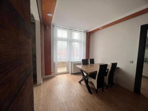 a dining room with a wooden table and chairs at Gera Apartment in Gera