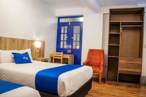 Pokój hotelowy z łóżkiem i krzesłem w obiekcie Estancia San Pedro Hotel w Cuzco