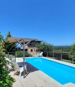 a swimming pool with a pergola next to a house at MiraSierras -casas vacacionales- in Villa General Belgrano