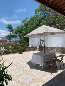 una mesa y sillas bajo una sombrilla en un patio en Casa de la Abuela, en Ajijic