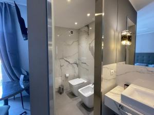 a bathroom with a white toilet and a sink at Dimora San Gregorio Luxury Rooms in Palermo