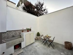 a kitchen with a sink and a table with chairs at MiMì House in Nardò