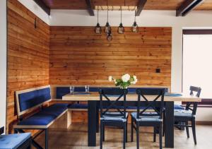 uma sala de jantar com uma parede de madeira e uma mesa e cadeiras em Laspopas em Guzowy Piec