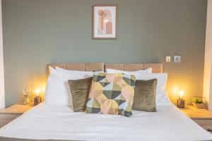 a bedroom with a white bed with pillows at City centre apartment with roof terrace. in Birmingham