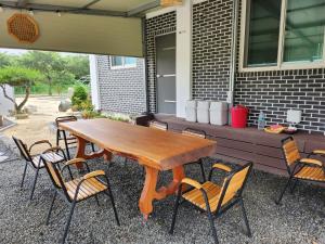 a wooden table and chairs on a patio at Seoak Stay in Gyeongju