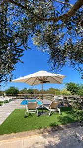 two chairs and an umbrella next to a pool at CAN DAMIA 3 in Cala Saona